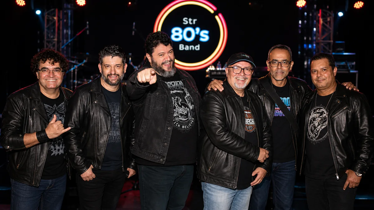 Banda STR80 no palco com letreiro neon Str 80's Band